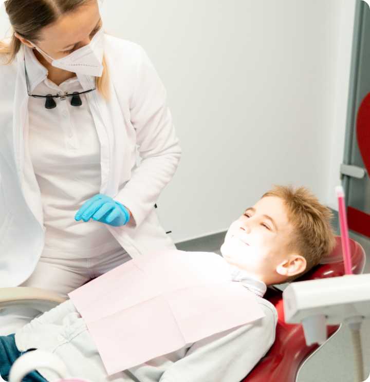 Child is smiling on the dental seat