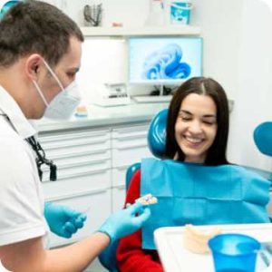 Female patient is smiling seating on the dental seat